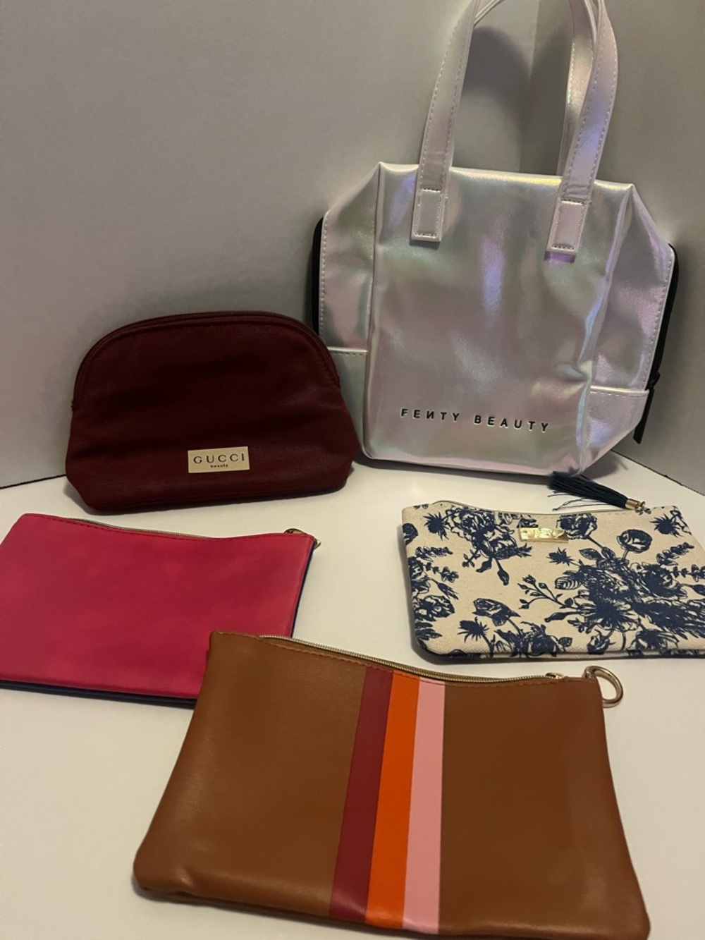 Assorted small cosmetic bags including Fenty Beauty and Gucci